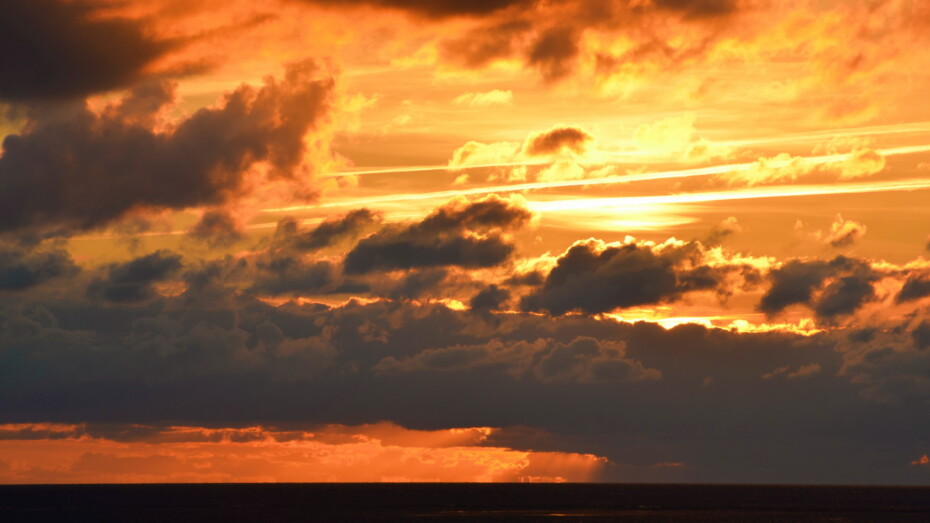 Sonnenuntergang hinter Wolken orange Gold Gelb große viele Wolken dunkel