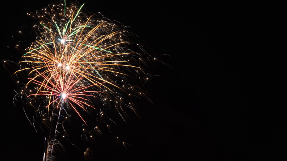 Silvesterfeuerwerk schwarzer Himmel Rakete Rot Grün Gelb Weiß