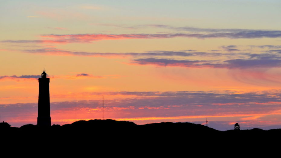 Leuchtturm vorm Sonnenuntergang Silhouette Landfläche Wolken Rot Blau