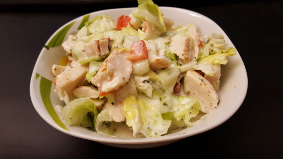 Salat Hähnchenfleisch Kräuter Gewürze Eisbergsalat Dressing Paprika in einer kleinen Schale